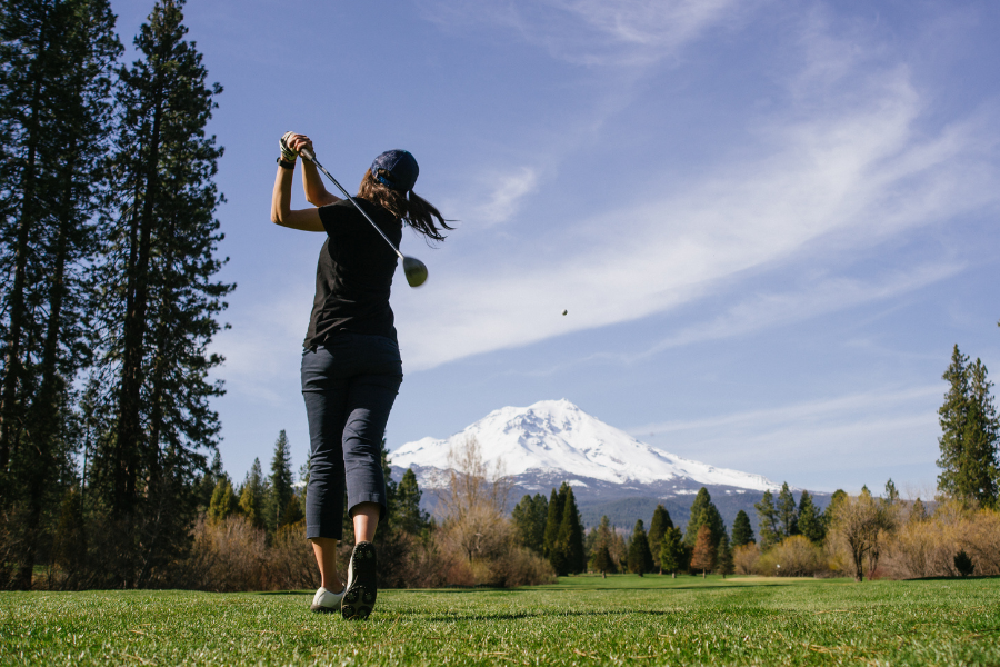 Woman golfer with mountain in background